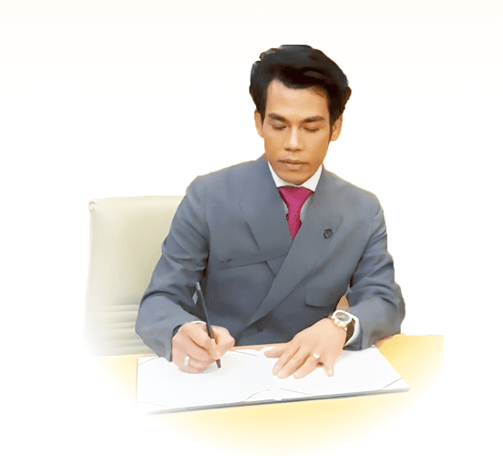 Ter seated at a desk, writing